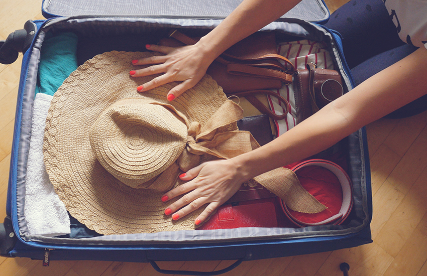 A suitcase full of clothes and a hat