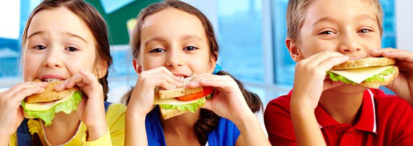 Three kids eating healthy sandwich