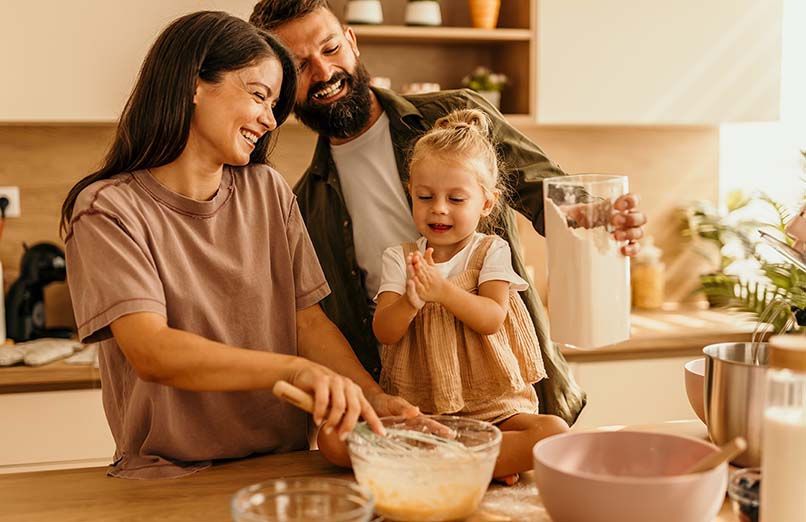 Happy family baking together in the kitchen having fun. 