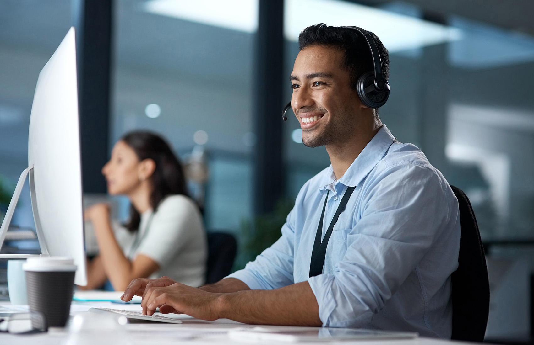 Person wearing a headset working on a computer in an office.