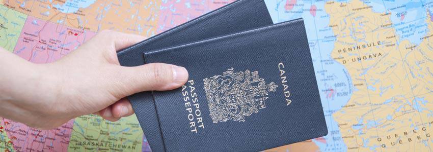 Deux passeports canadiens devant une carte du Canada