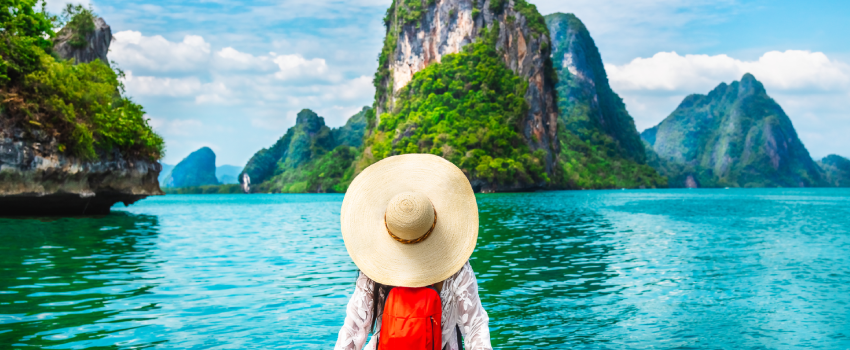 Woman with a hat on the water's edge admiring the landscape 