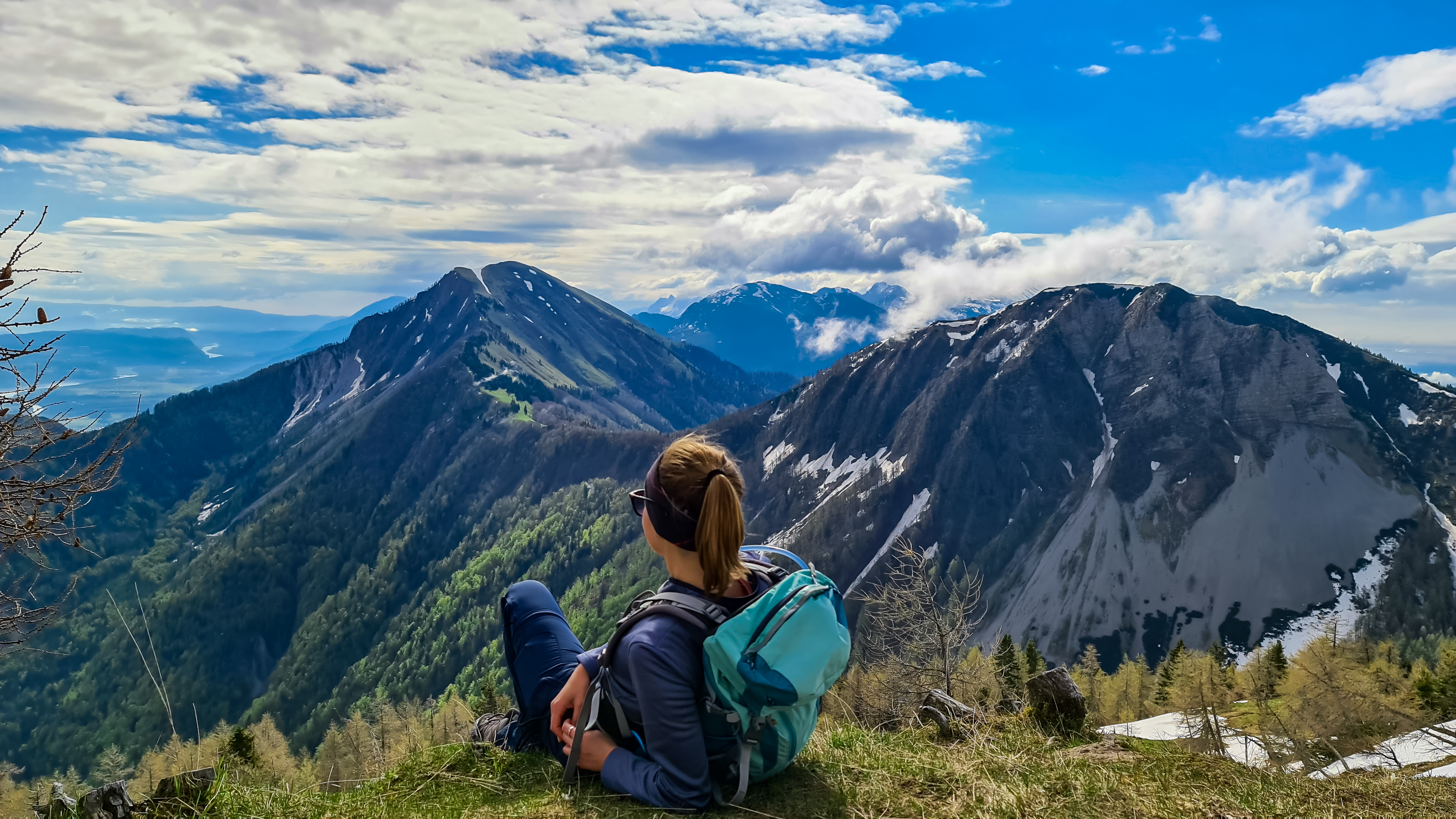 Female hiker having a break in spring on the summit of Frauenkogel in the Karawanks in Carinthia, Austria, Europe. Borders with Slovenia. Triglav National Park. 