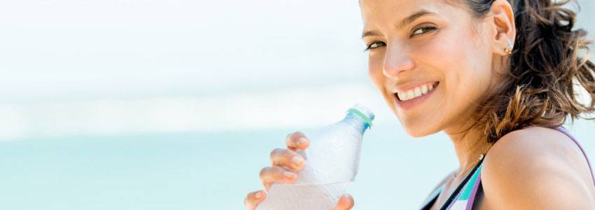 A woman drinking water after doing sports