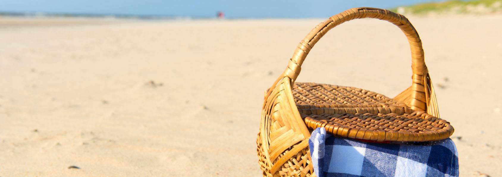 A picnic basket on the beach sand
