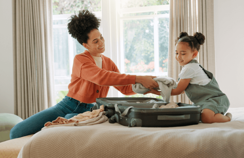 Mother preparing travel luggage with her daughter