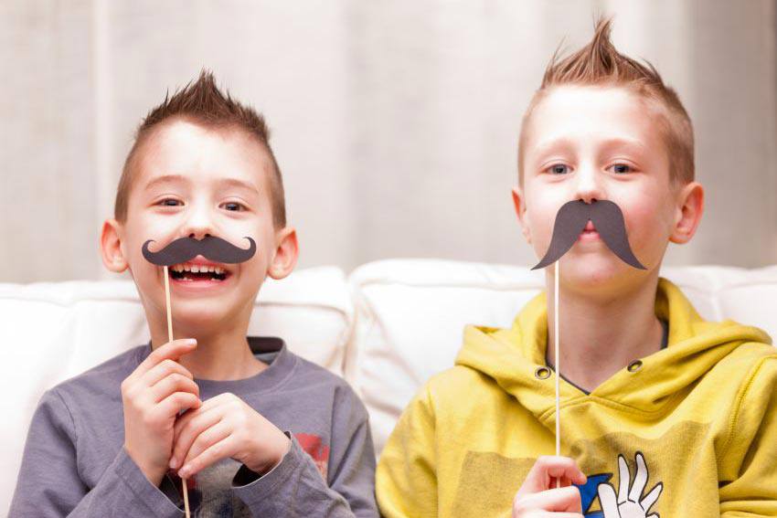 Enfants avec des moustaches en carton