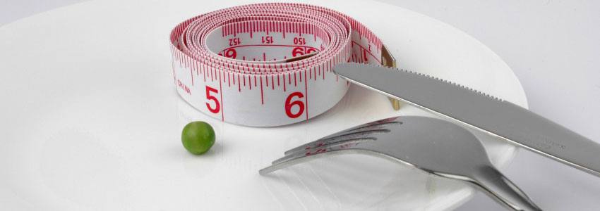 A plate with a tape measurer and a pea on it